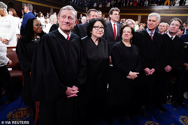 Supreme Court Chief Justice John Roberts stands with Justices Sonia Sotomayor, Elena Kagan, Neil Gorsuch and Brett Kavanaugh in the House of Representatives ahead of U.S. President Joe Biden's third State of the Union address in March