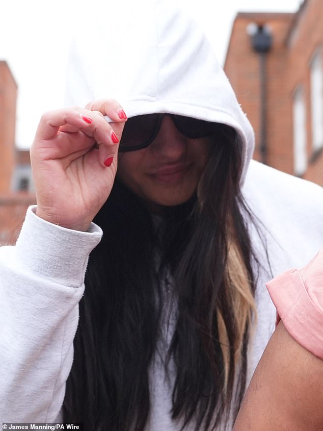 Mrs De Sousa Abreu attempted to cover her face as she left Uxbridge Court