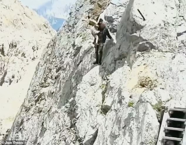 The baby clings to the father as he feels his way along the section of the Via Ferrata that is considered difficult