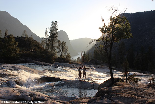 Two women pose for a photo at Rancheria Falls, where the toilet paper was found