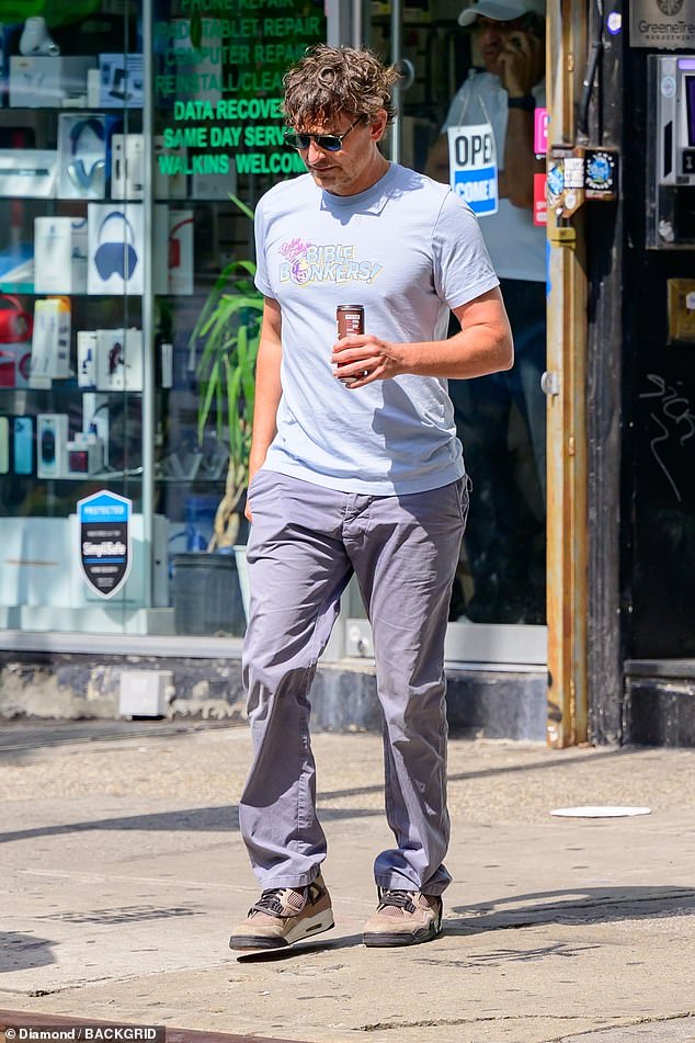 Bradley wore a light blue T-shirt with dark blue pants and brown sneakers, along with black sunglasses