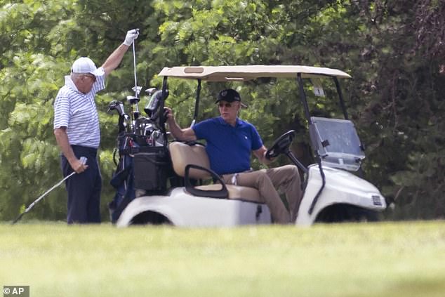 President Joe Biden sits in a golf cart while playing golf with his brother Jimmy in 2023