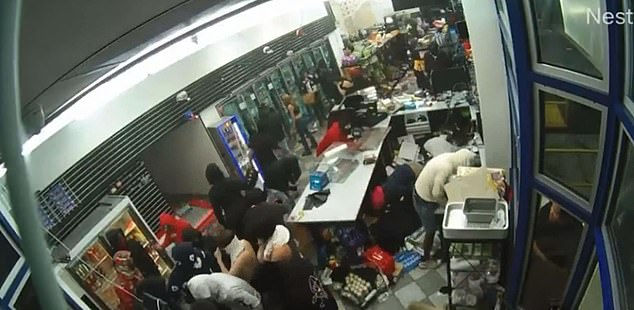 A huge crowd robs an Oakland gas station after a car crashes into the glass to break in