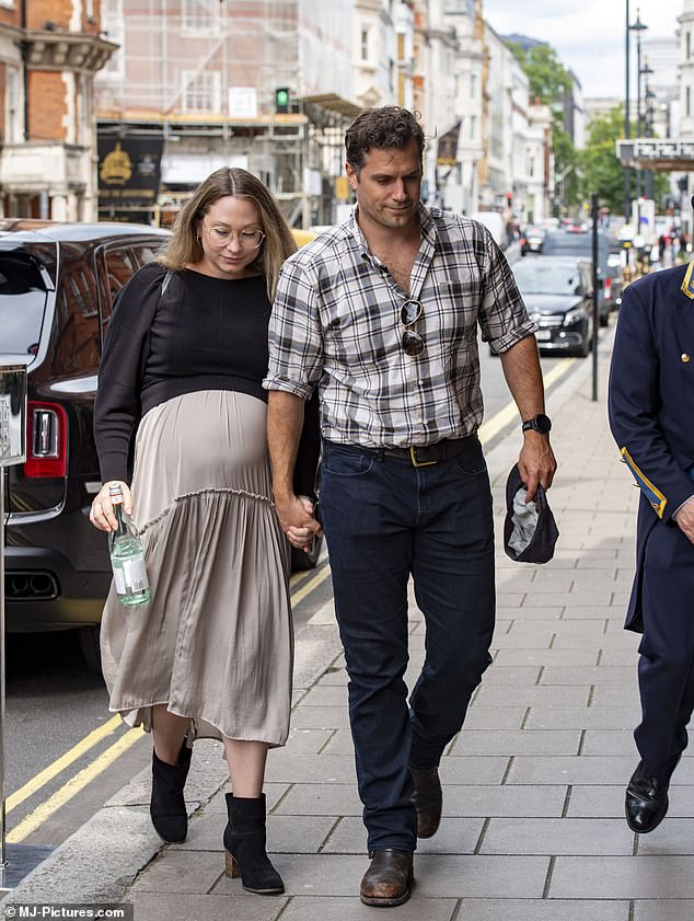 He wore a gray and white checked shirt with dark blue jeans and a pair of neat brown shoes