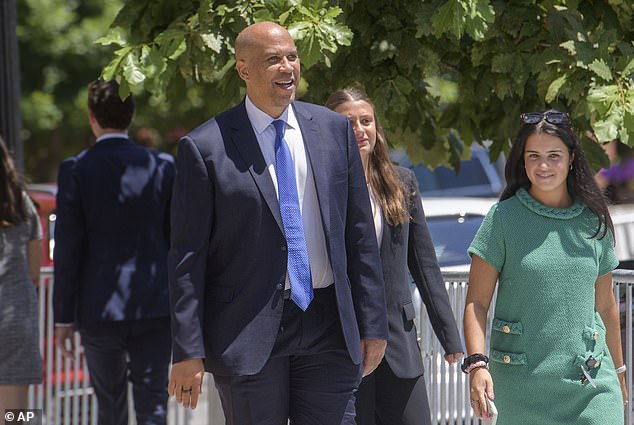 Sen. Cory Booker, D-N.J., came out to hand out water bottles to reporters, but he declined to answer questions from the press about the private event