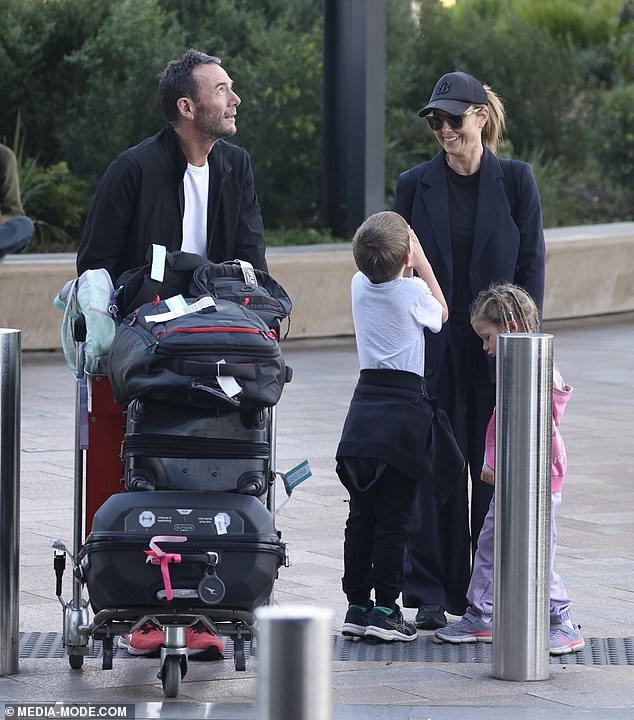 She complemented her natural beauty with a light layer of nude makeup and looked every inch the devoted mother as she held her children's hands as they walked through the busy terminal