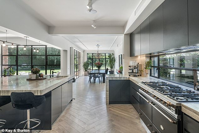 Designed in a classic Tudor Revival style, the beautiful home features impressively scaled living spaces and large windows. Pictured: the kitchen