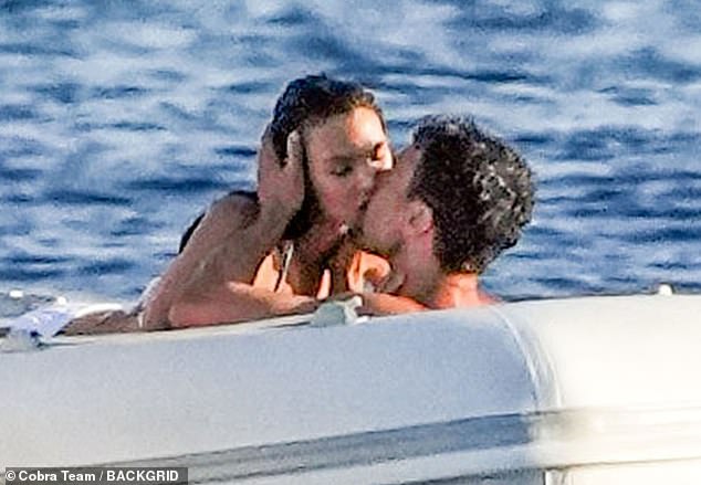 DiCaprio's 26-year-old bikini-clad girlfriend loomed over the 39-year-old British star as he held her head in his hands as they kissed.