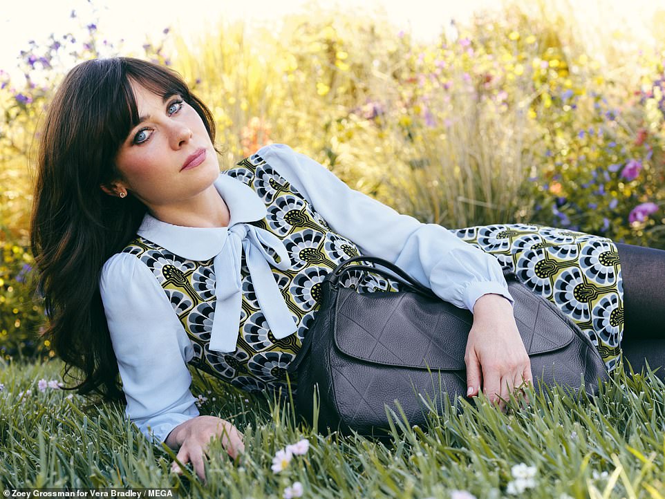 The Physical star nestled into a large navy bag and wore a blue, black and green floral dress with black stockings.