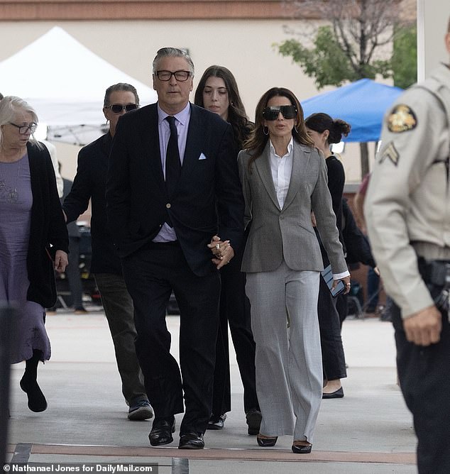 Baldwin holds hands with his wife Hilaria as he leaves the courthouse Friday, moments after his manslaughter case was dismissed by a judge