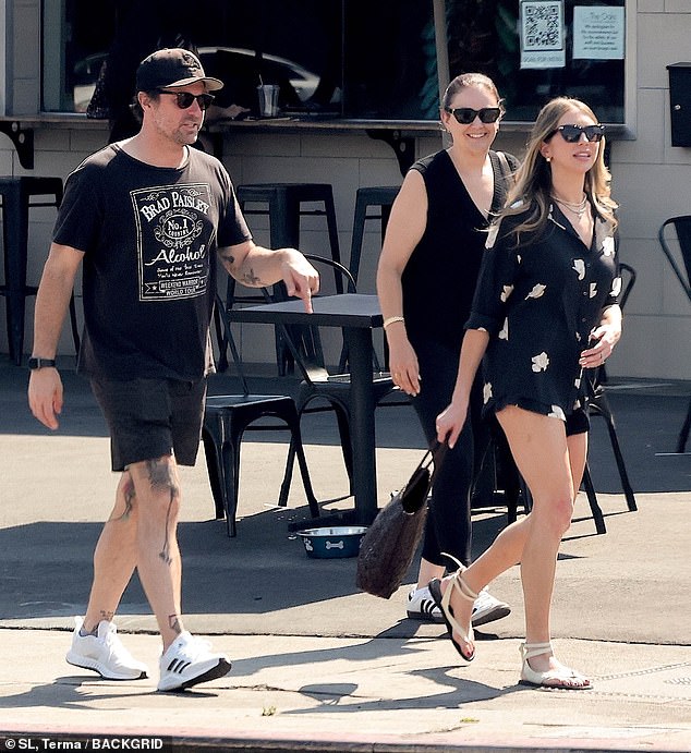 She looked radiant in a summery black blouse with a white floral print and matching shorts