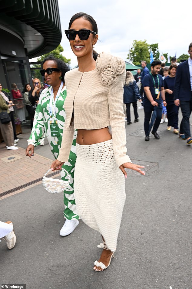 She carried her belongings in a small white handbag and hid her eyes behind black sunglasses as she posed for the photos.