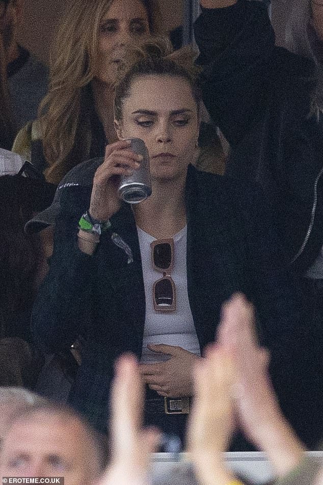 Cara put on a trendy show as she wore a tailored blue jacket that she layered over a white T-shirt