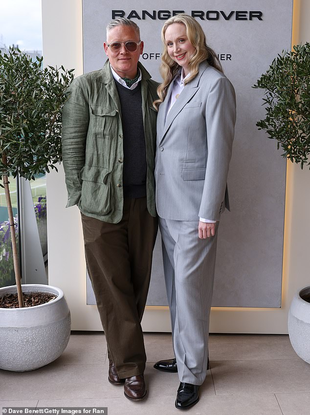 The celebrity also took the opportunity to be photographed with British fashion designer Giles Deacon, who looked dashing in a dark gray knitted cardigan and brown trousers