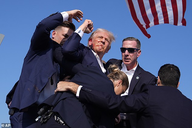 Trump raised his fist to the crowd and did not appear seriously injured as he walked off the stage on his own, surrounded by Secret Service.