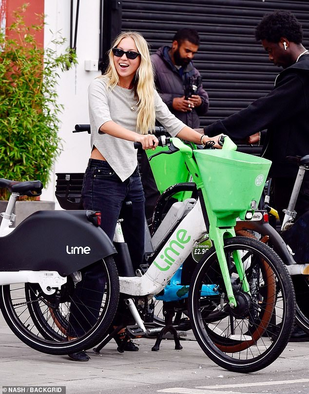 Lila looks incredibly chic in her sunglasses, jeans and Miu Miu leather ballerinas as she rides one of the pay-per-ride bikes