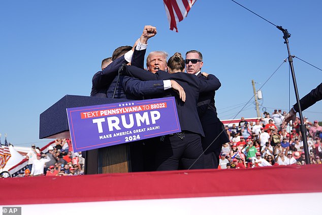 Republican presidential candidate and former President Donald Trump gestures as he is surrounded by U.S. Secret Service agents as he leaves the stage at a campaign rally