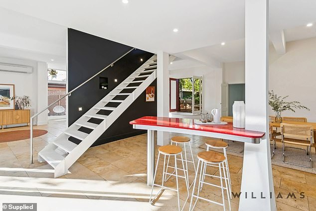 The sleek, modern staircase divides the living and dining area on the ground floor