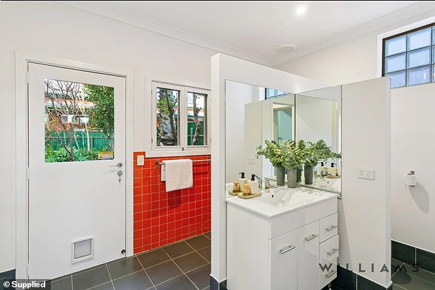 The striking red tile provides a welcome touch of colour in a home with a strong emphasis on minimalism