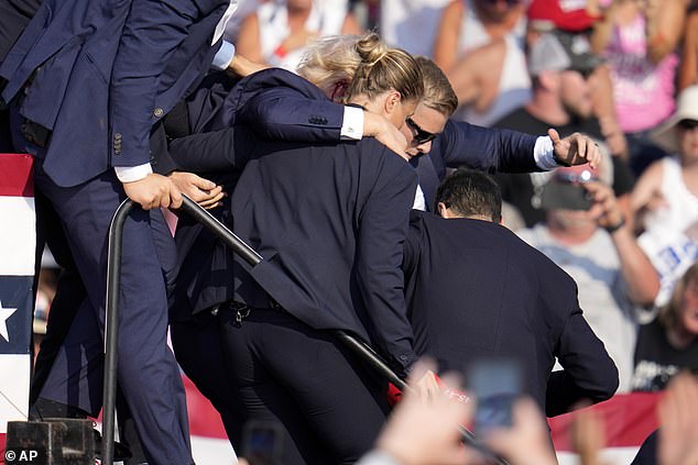 Republican presidential candidate and former President Donald Trump is helped off the stage by U.S. Secret Service agents during a campaign rally in Butler