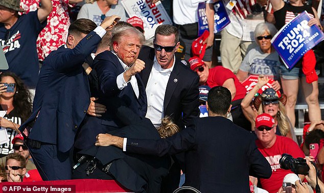 The former US president was seen with blood on his right ear as he was surrounded by security guards, who pushed him off the stage as he performed his first dance move to the crowd