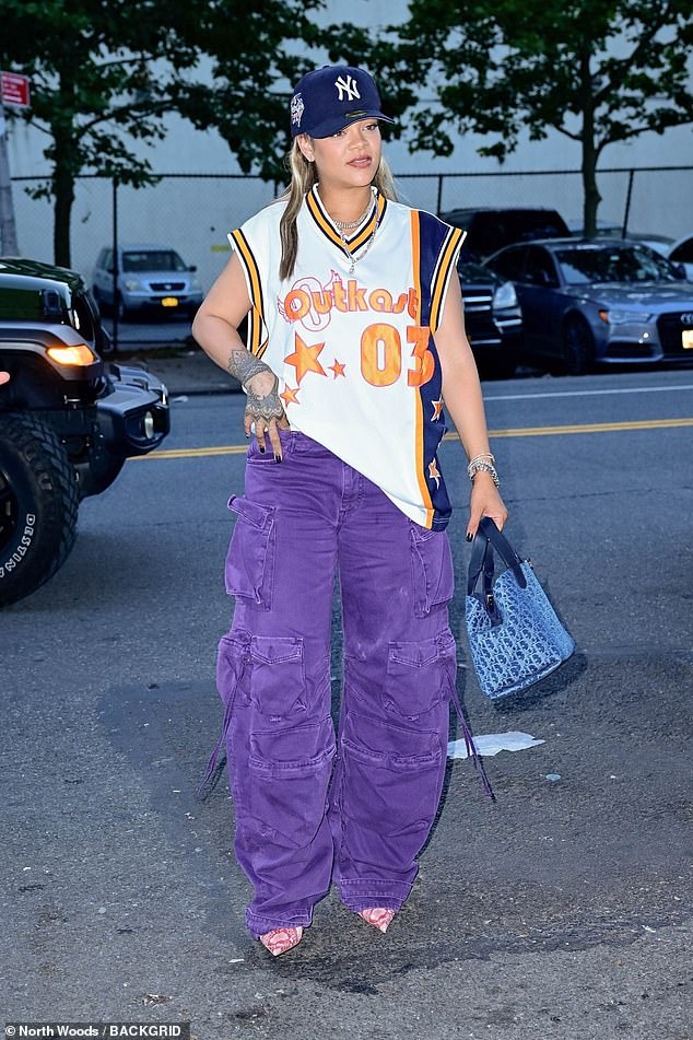 The 36-year-old Bajan billionaire wore a NY Yankees cap over her blonde wig, a shirt from six-time Grammy-winning rap duo Outkast, purple denim cargo pants and pink reptile heels