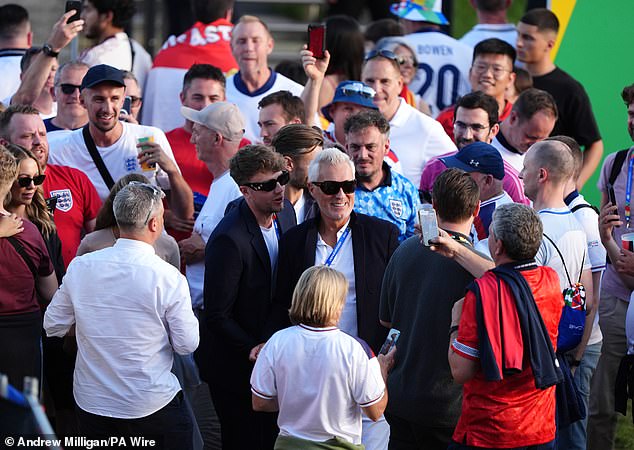 Radio presenter Roman Kemp and his father Martin, a musician and actor, are surrounded by English fans upon arrival