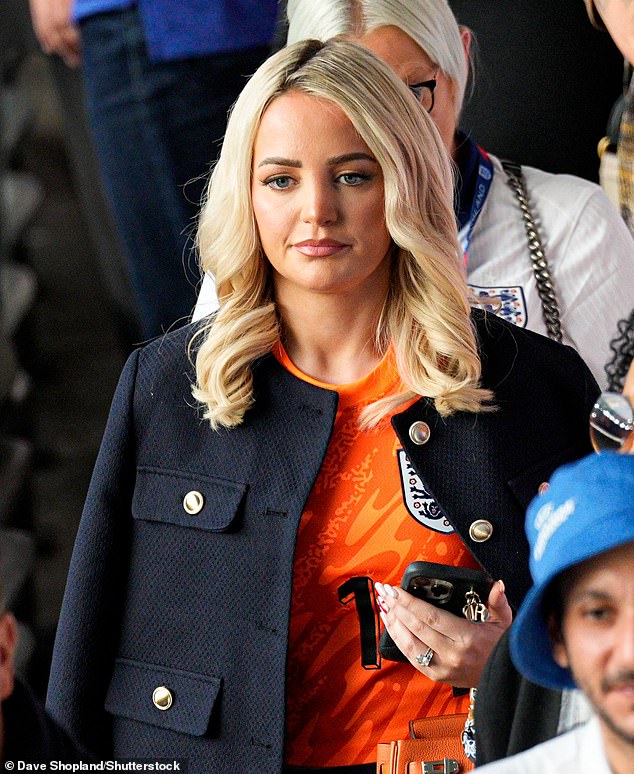 Pictured: Megan Davison - Jordan Pickford's wife - arrives in an orange England shirt and navy jacket