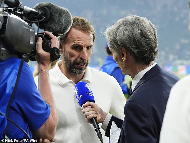 Southgate is pictured standing on the pitch with ITV Sport shortly after the end of the match on Sunday evening