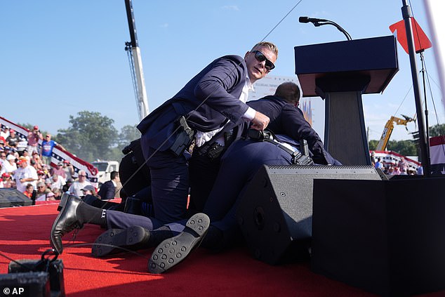 The former president was seen clutching his head and ducking as screams were heard from terrified bystanders who ran outside