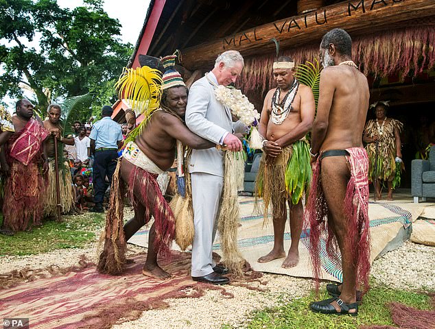 Charles is given a grass skirt to wear before receiving a chief title during a visit to the Chiefs' Nakamal during a visit to the South Pacific island of Vanuatu