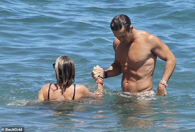 The loved-up couple held hands as they relaxed in the warm waters of the Spanish coast