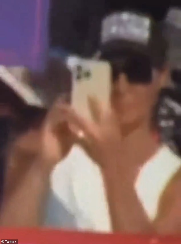 Viral footage shows an unidentified woman — wearing sunglasses, a white shirt and a black hat — pulling out her phone as shots ring out at the rally in Pennsylvania on Saturday