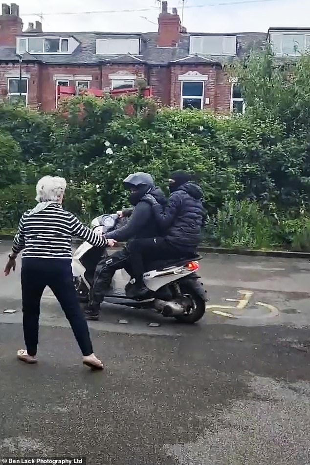 One of the elderly passersby who bravely intervened and scared off the attackers is seen approaching them despite the risks to her own safety. The attackers made a quick getaway