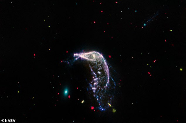 In this mid-infrared image of the Penguin and Egg galaxy, the egg is seen in bright green and the penguin in pink and purple.