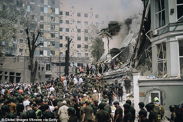 People clear rubble from a building of one of Ukraine's largest children's hospitals, which was partially destroyed by a Russian missile attack on July 8, 2024 in Kiev, Ukraine