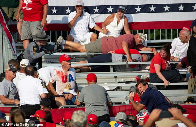 Trump supporters are seen in the stands covered in blood after guns were fired at Republican candidate Donald Trump during the campaign event