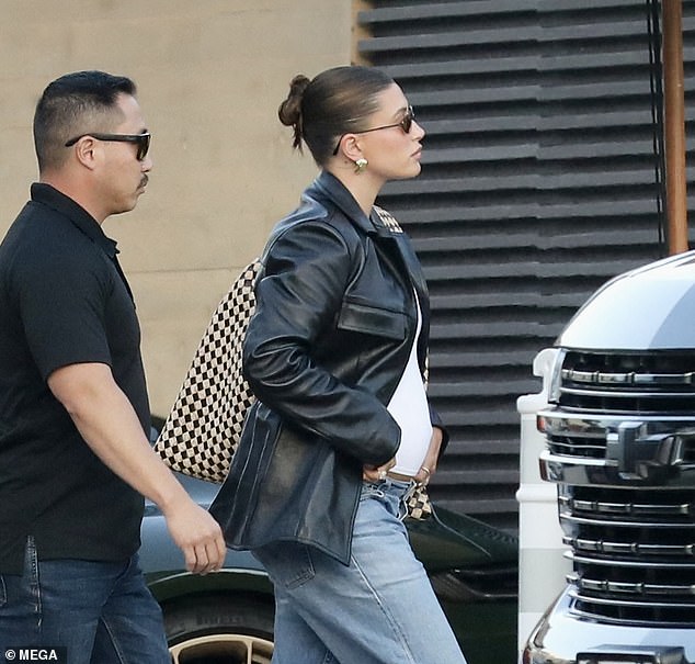 The model wore black low pointed heels, chunky earrings, black sunglasses and a large patterned bag