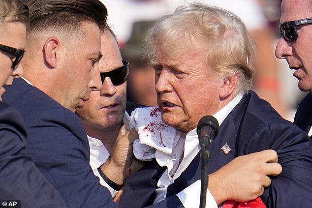 Trump is surrounded by US Secret Service at a campaign rally in Butler after a bullet fired by 20-year-old Thomas Matthew Crooks grazed his ear