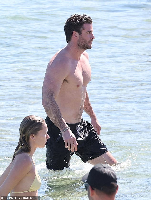 The couple looked relaxed and happy as they splashed in the waves together and emerged refreshed after a swim