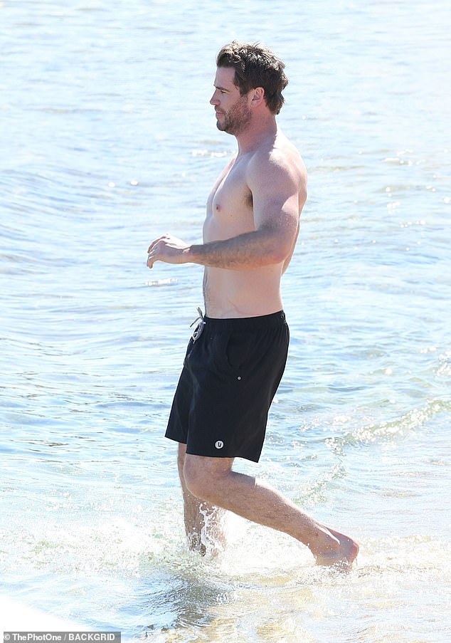 Liam, 34, kept it casual in a pair of black board shorts