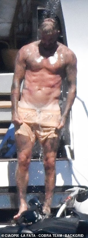 The former footballer, 49, showed off his muscular figure as he went shirtless in lemon yellow swimming trunks before donning a life jacket to hop on a jet ski