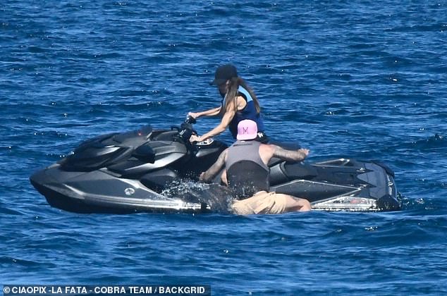 David was seen trying to get on the jet ski to sit behind his wife