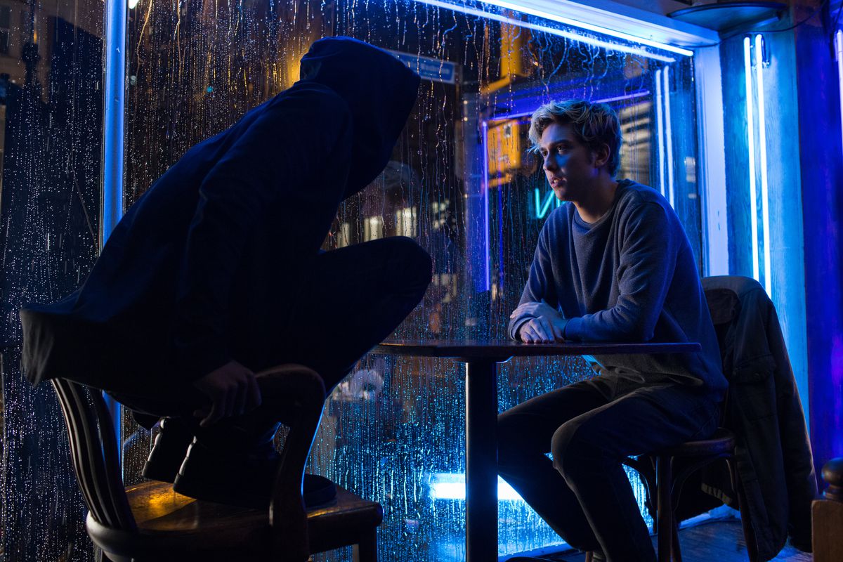 In a still from Netflix's live-action film Death Note, Lakeith Stanfield stands in a chair as L, while sitting opposite Nat Wolff as Light