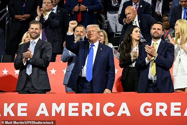 The crowd cheers as Trump raises his fist next to his son Eric and his running mate JD Vance