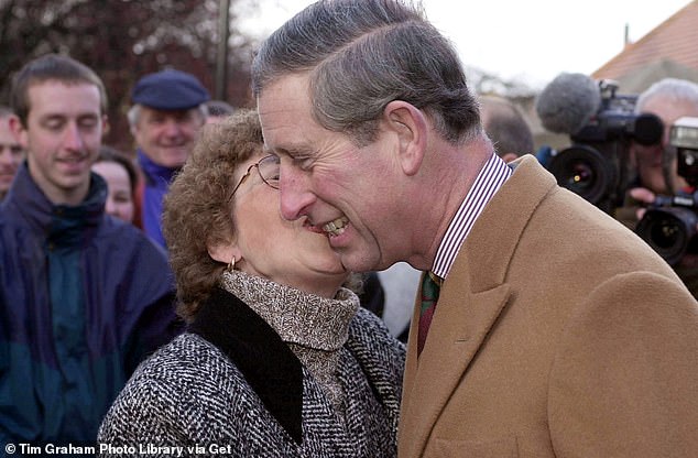 Prince Charles receives a kiss from a royal fan during his visit to York to view the water damage, 2000