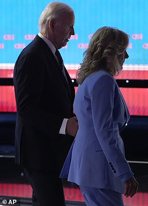 Biden grabs his wife First Lady Jill Biden's arm to keep him off the debate stage in Atlanta, Georgia in June