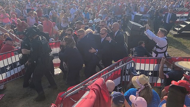 A team of at least nine Secret Service agents swarmed Trump as they moved him from the stage to his armored Chevrolet