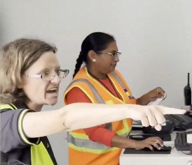 The strange moment begins with the female officer with glasses, dressed in black and a bright yellow vest, shouting at the crowd. (pictured: she is shouting next to her colleague)