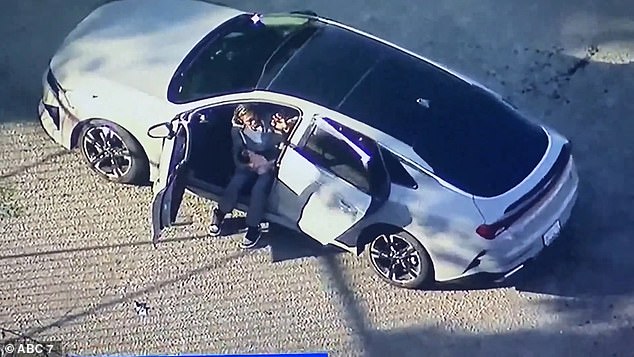 The man is seen holding the baby after stopping the car at high speed at the end of the chase